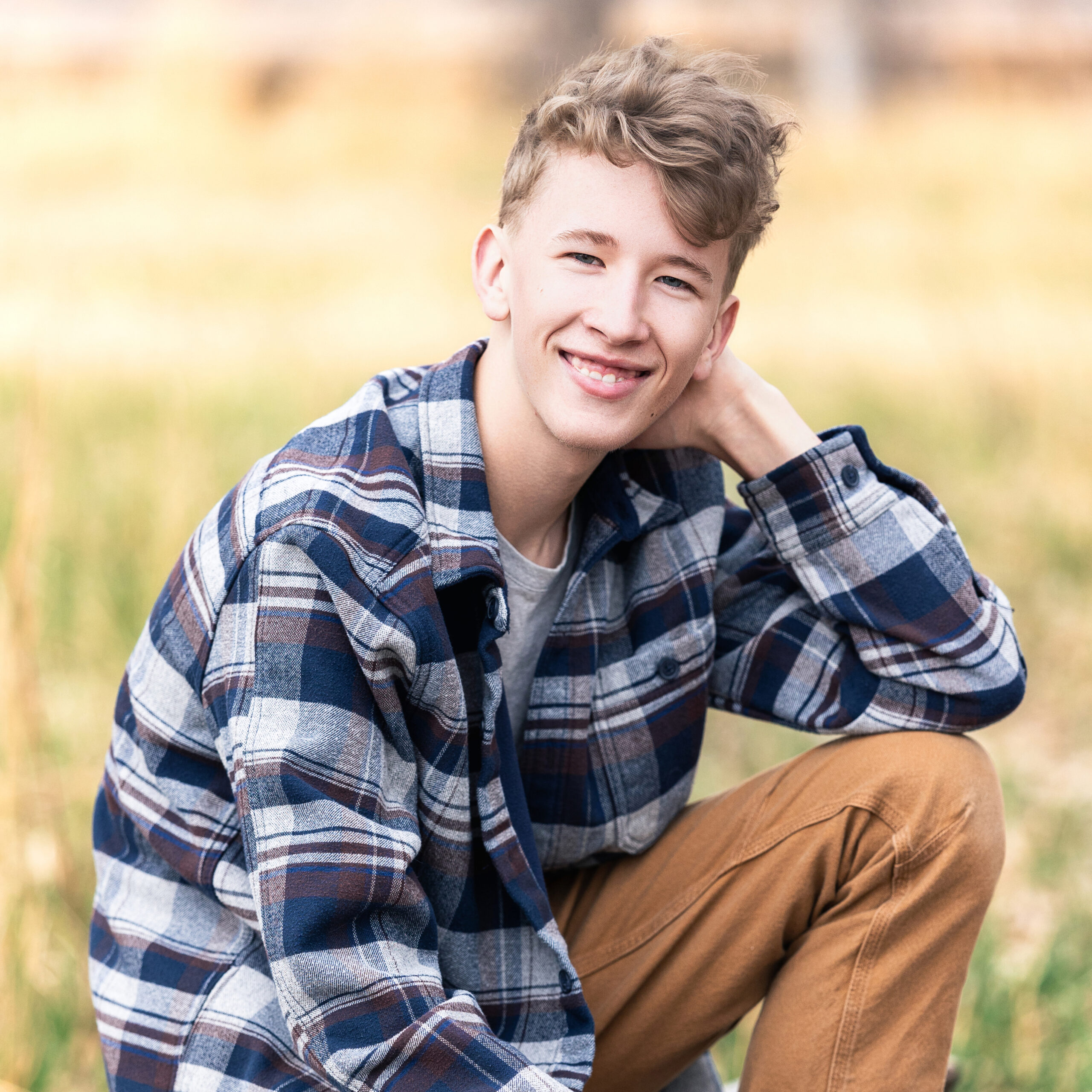 Colorful senior photo of teen guy smiling outdoors, selected for his school’s senior slideshow, captured by Northern Colorado senior photographer Heather Lilly