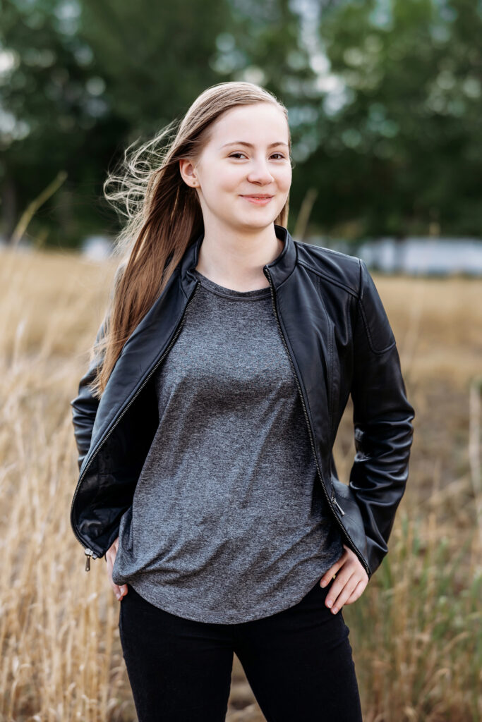 Senior portrait of an emo-style teen girl smiling softly, photographed by Heather Lilly Photography in Northern Colorado despite not being excited about pictures