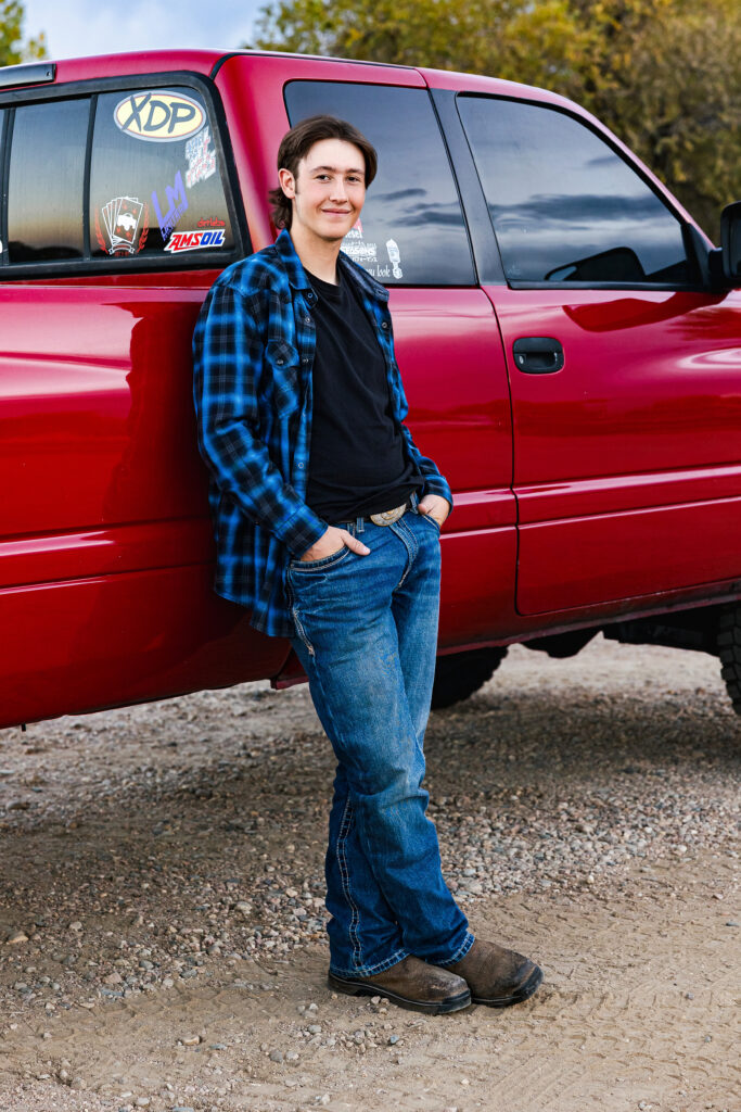 Editorial outdoor senior photo of a high school guy in front of his red truck, captured in Greeley, Colorado by Heather Lilly Photography