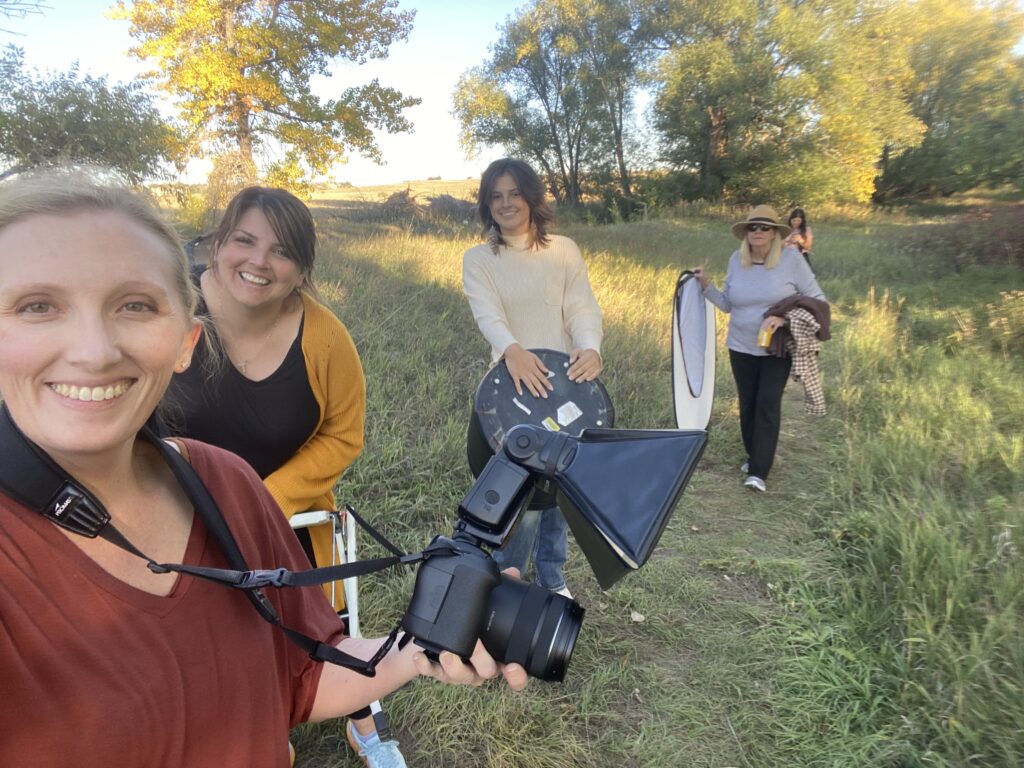 photographer with team carrying reflectors during windy outdoor session in Northern Colorado