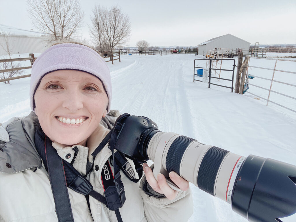 female photographer in snow with Canon camera during cold Colorado session