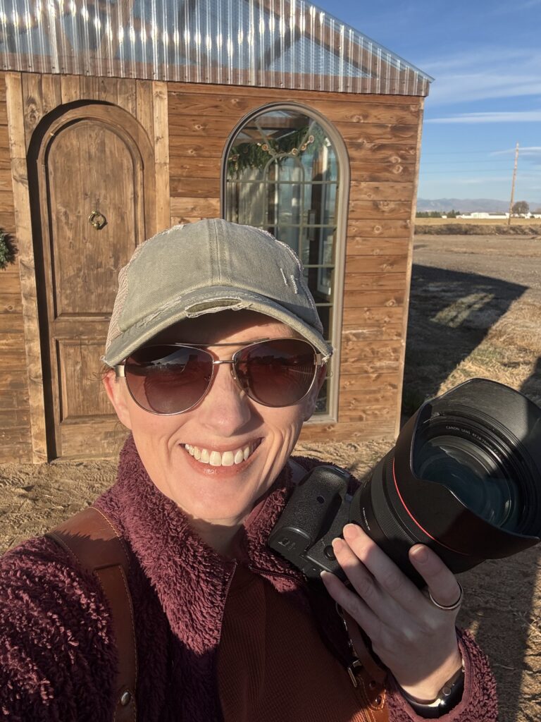 photographer smiling outside sunny Colorado photo studio during branding session