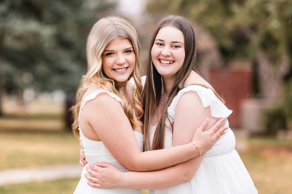 Close-up best friend photo in white dresses after senior portrait session