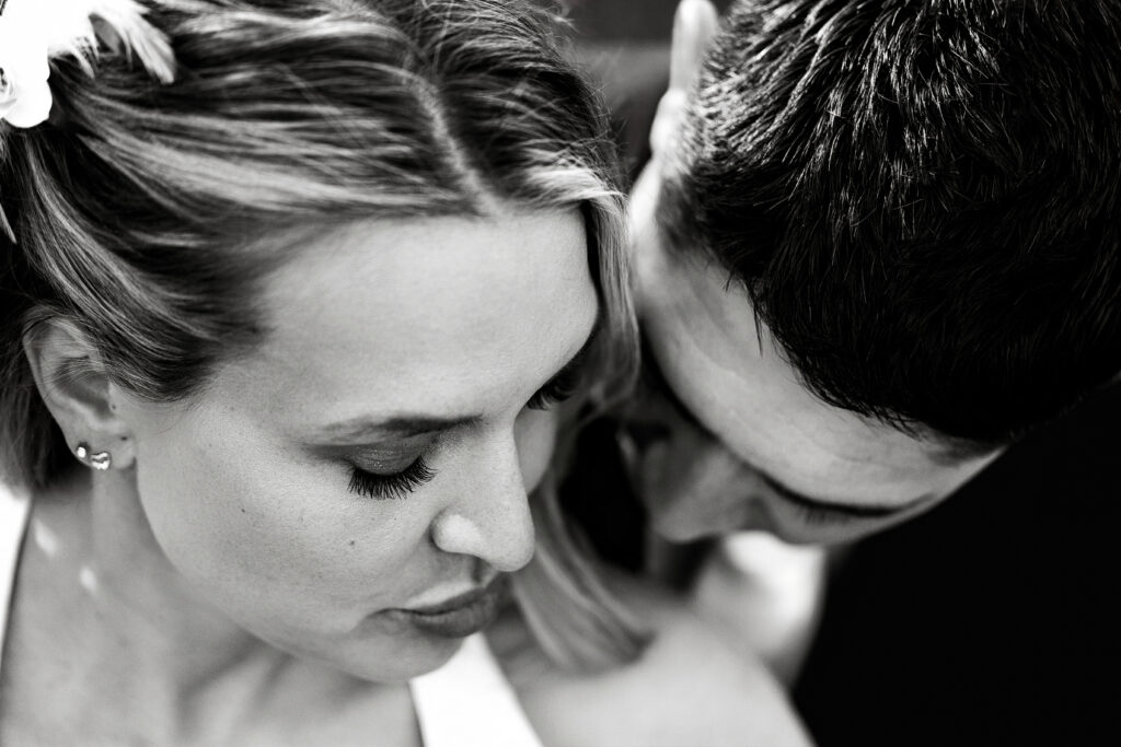 Husband and wife snuggling during their 15-year anniversary portraits at Lions Park in Cheyenne, Wyoming — a recreation of their 2010 wedding photo, captured by Heather Lilly Photography.