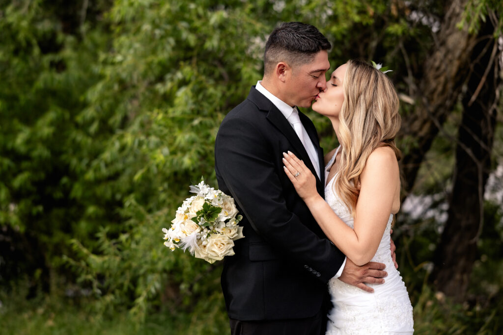Husband & wife sharing a kiss during their 15-year anniversary portraits at Lions Park in Cheyenne, Wyoming, captured by Heather Lilly Photography.