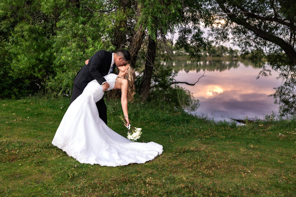 Husband and wife dip-kissing during their 15-year anniversary portraits at Lions Park in Cheyenne, Wyoming — a recreation of their 2010 wedding photo, captured by Heather Lilly Photography.