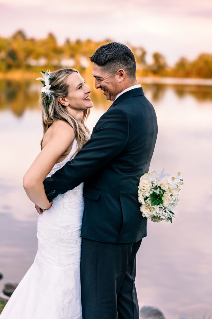 Husband and wife smiling at each other during their 15-year anniversary portraits at Lions Park in Cheyenne, Wyoming — captured by Heather Lilly Photography.