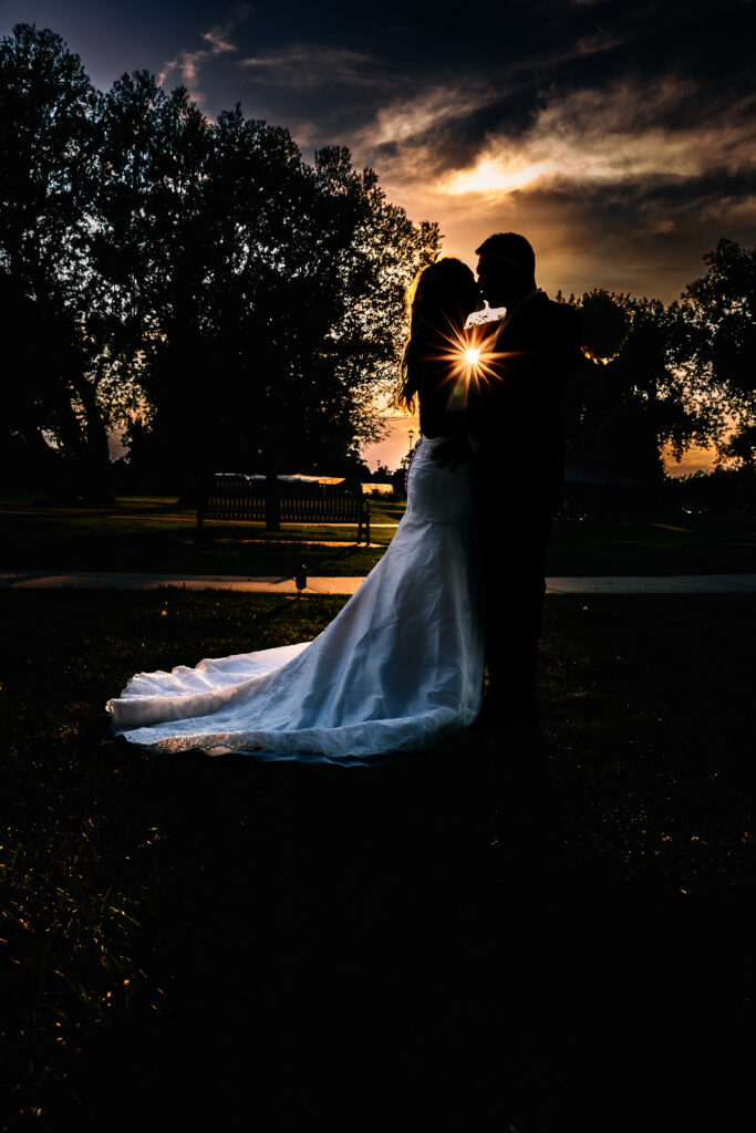 Husband and wife silhouette with sunburst on their hearts during their 15-year anniversary portraits at Lions Park in Cheyenne, Wyoming, captured at sunset by Heather Lilly Photography.