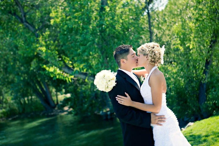 Husband and wife kissing during their wedding portraits at Lions Park in Cheyenne, Wyoming, captured by Heather Lilly Photography in 2010.