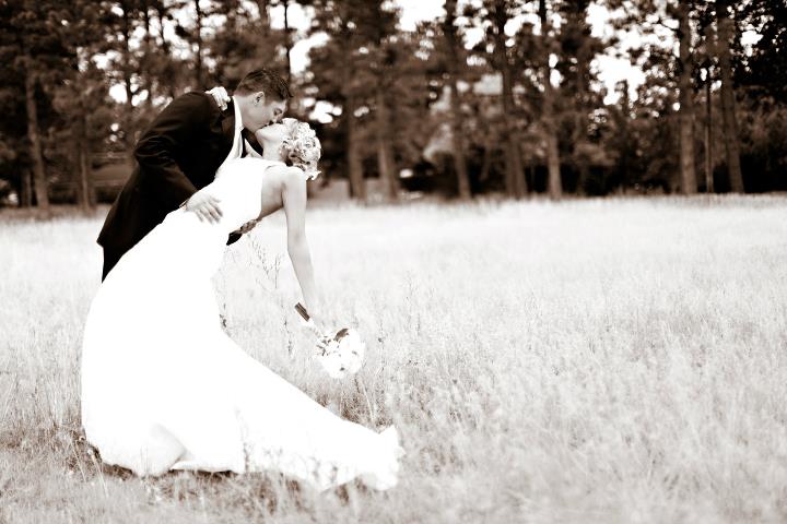 Husband and wife dip-kissing during their wedding portraits at Lions Park in Cheyenne, Wyoming, captured by Heather Lilly Photography in 2010.