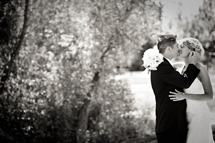 Husband and wife kissing during their wedding portraits at Lions Park in Cheyenne, Wyoming, captured by Heather Lilly Photography in 2010.