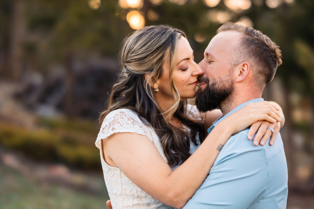 Husband and wife kissing during vow renewal at Lily Lake in Estes Park Colorado, photographed by Northern Colorado photographer Heather Lilly at golden hour in the mountains.