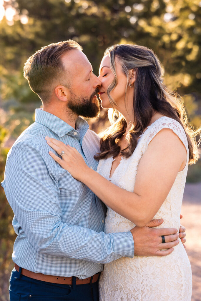 Husband and wife kissing during vow renewal at Lily Lake in Estes Park Colorado, photographed by Northern Colorado photographer Heather Lilly at golden hour in the mountains.