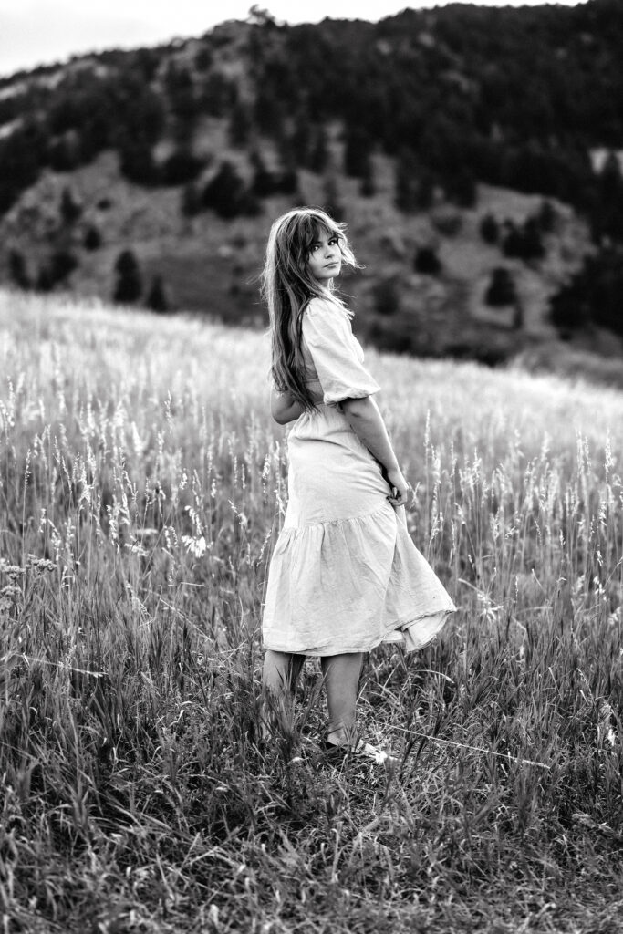 Editorial style headshot of Eden Alley, Colorado wedding photographer, in monochrome with mountain backdrop.
