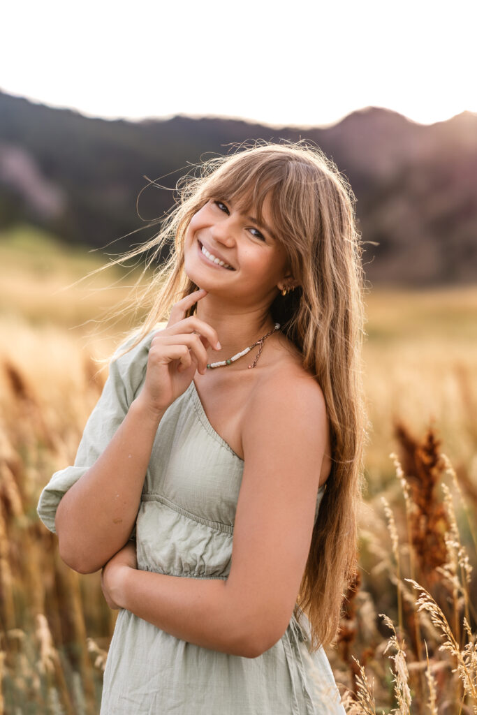 Vibrant film-inspired portrait of Eden Alley with hair blowing in wind, Boulder foothills behind her.