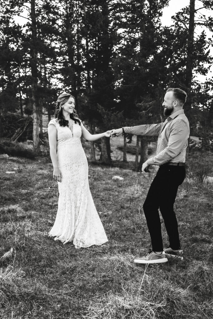 Husband and wife dancing during vow renewal at Lily Lake in Estes Park Colorado, photographed by Northern Colorado photographer Heather Lilly at golden hour in the mountains. Black & white photo.