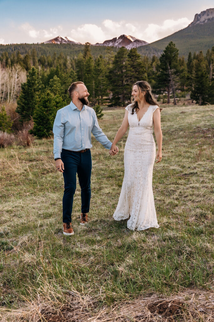 Husband and wife walking during vow renewal at Lily Lake in Estes Park Colorado, photographed by Northern Colorado photographer Heather Lilly at golden hour in the mountains.