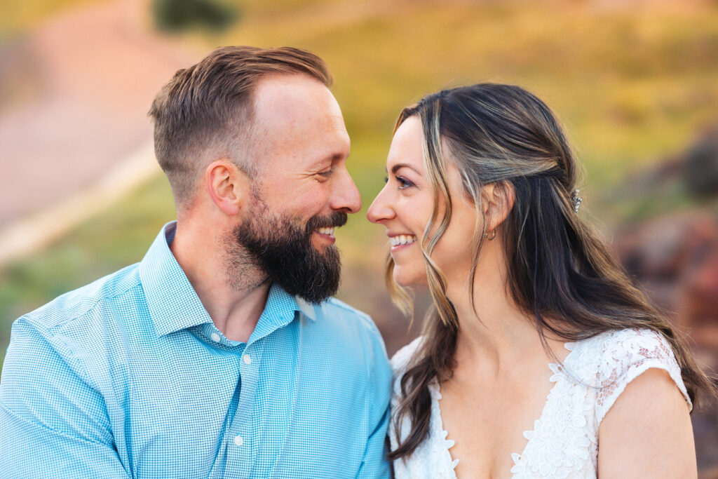 Husband and wife smiling at each other vow renewal at Lily Lake in Estes Park Colorado, photographed by Northern Colorado photographer Heather Lilly at golden hour in the mountains.