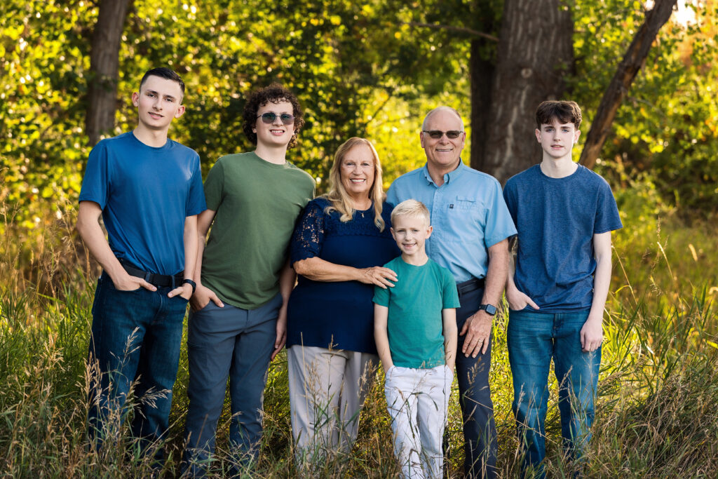 Grandparents smiling together in soft golden light during outdoor family portraits captured in Northern Colorado with Heather Lilly Photography.