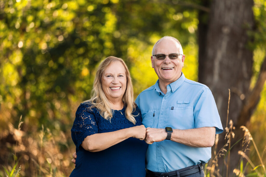 Parents posing side by side in coordinating navy and light blue shirts during an heirloom family portrait session in Loveland, Colorado.