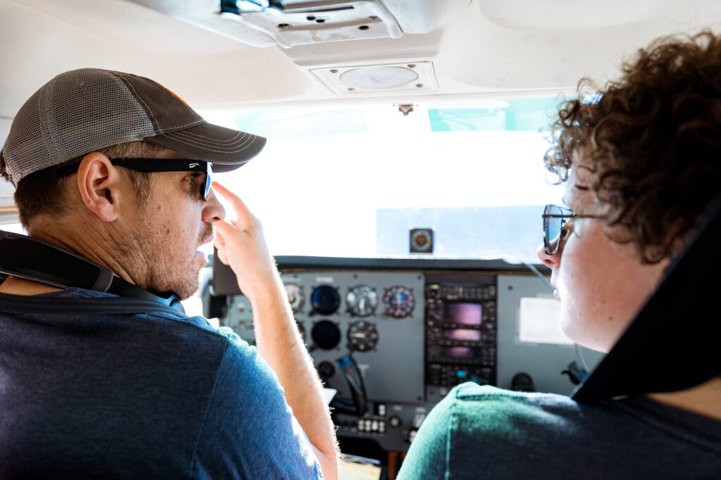Pilot & student standing in Cessna Skyhawk 172 during first flight in Colorado