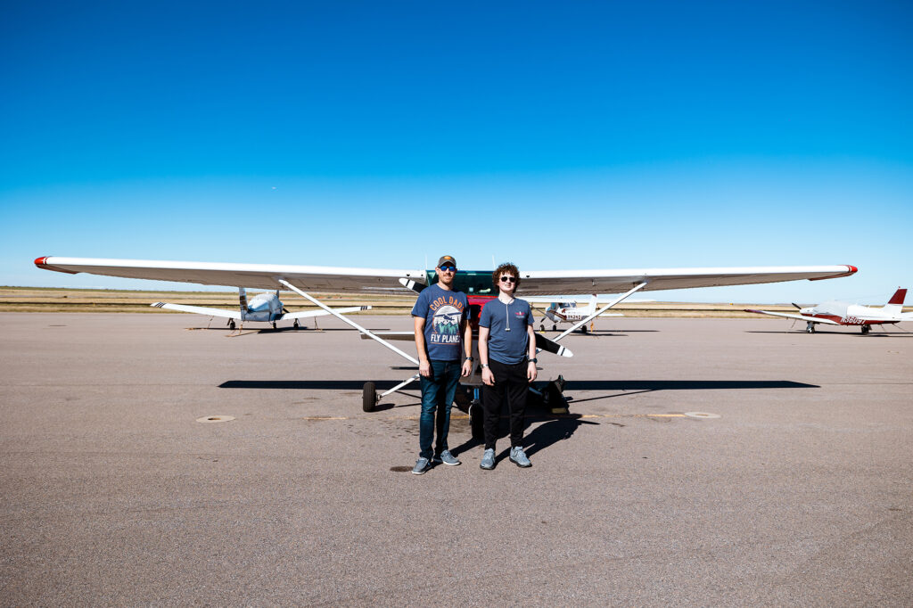 Pilot & student standing in front of Cessna Skyhawk 172 after first flight in Colorado