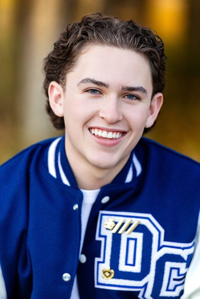 Close-up fall senior portrait of a young man with warm golden light and authentic expression, Northern Colorado senior photographer.